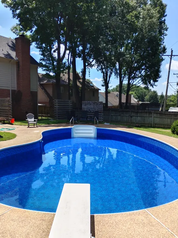 Kidney-shaped inground pool with a new liner and diving board