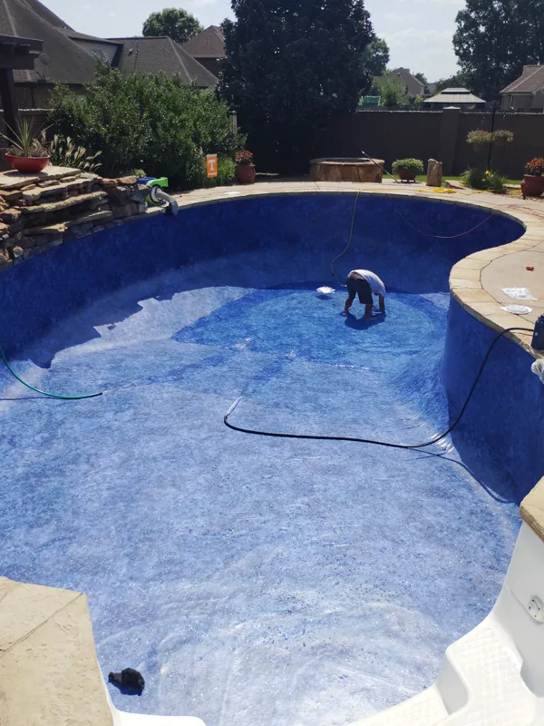 Technician working inside a pool while a new liner is set